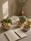 Mesa de linho com gengibre, curcuma, nozes, azeite e um caderno aberto